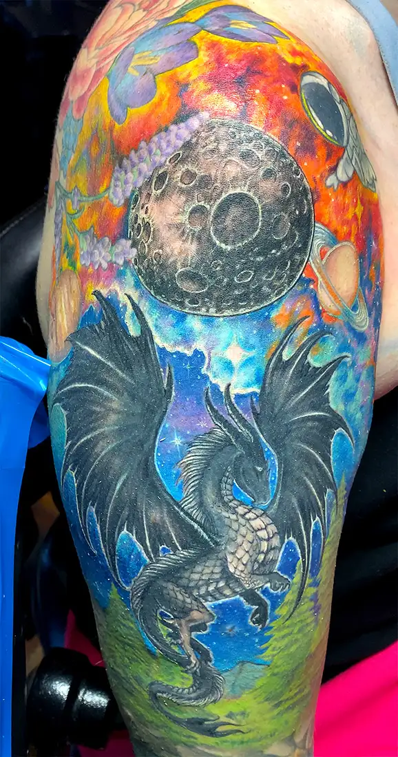 Fantasy dragon flies inito a galaxy filled nebula clored sky tattoo redo by Power Dude of Dudes Tattoos, Bronx NY