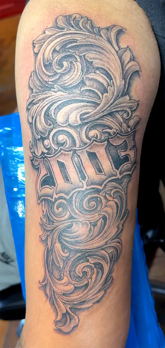 2003 year with a stylish flourish to accentuate it, ar tattoo in black and grey by Power Dude of Dudes Tattoos, Bronx NY